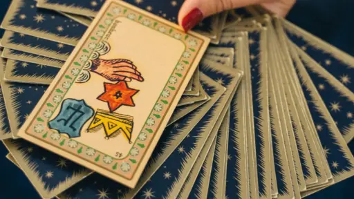 cartas del tarot con una mano sosteniendo la de arriba