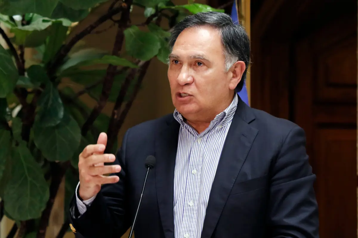 un hombre de traje hablando por un micrófono