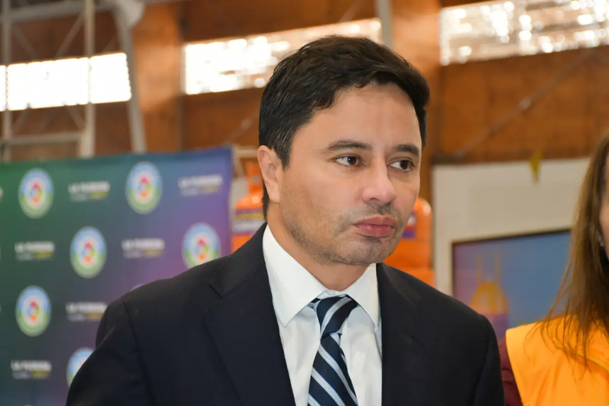 Rodolfo Carter con traje y corbata de pie junto a una muje