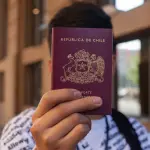 un hombre sosteniendo un pasaporte de Chile
