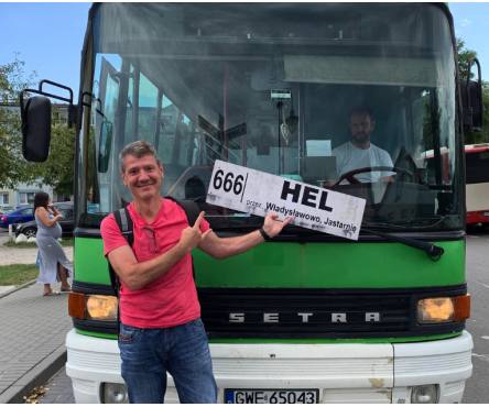 un hombre apunta el cartel que dice HEL en la parte delantera del autobus 666 - 