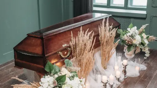 un ataúd café con flores alrededor
