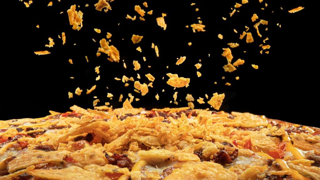 nachos cayendo a una pizza / 