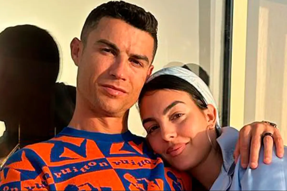 cristiano ronaldo y georgina rodriguez abrazados en una terraza frente a la ventana