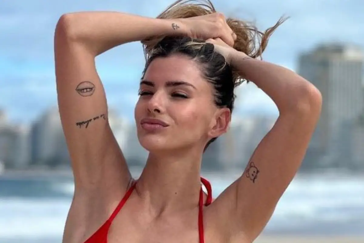 La China Suárez con las manos en la cabeza se sostiene el cabello y posa con bikini rojo en la playa
