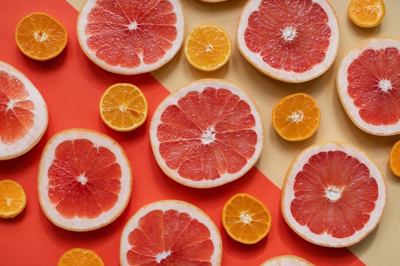 rodajas de Naranjas y pomelos sobre una mesa de dos colores / 