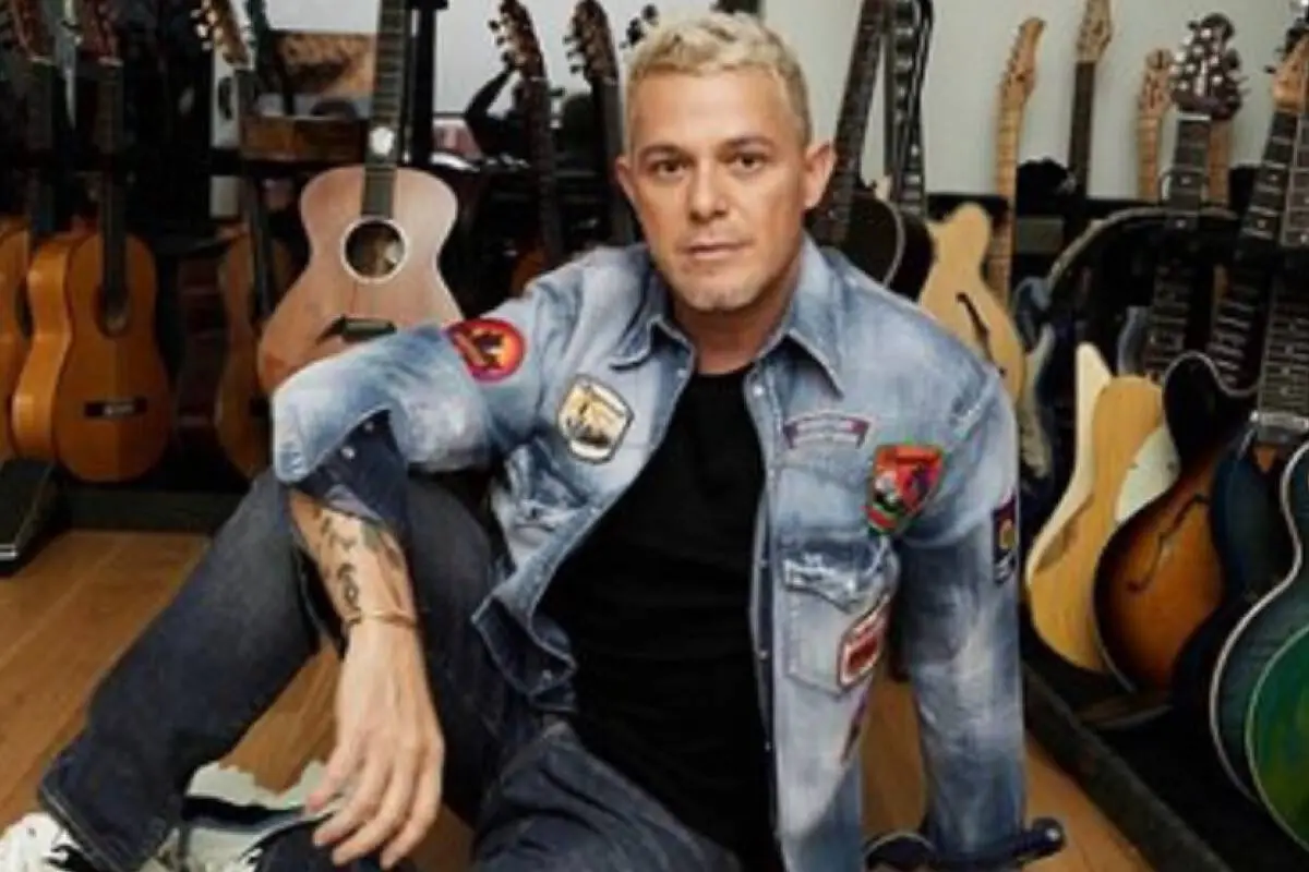 alejandro sanz sentado en el suelo y detrás suyo varias guitarras