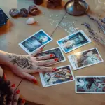 Una mujer que realiza una lectura de tarot en una mesa con varias cartas repartidas