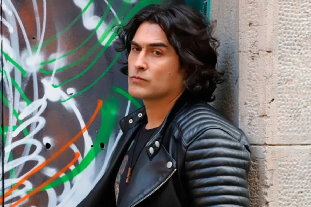 Daniel Guerrero apoyado contra una pared luciendo una chaqueta de cuero