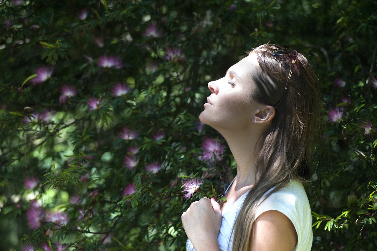 mujer respirando aire puro, junto a las plantas / 