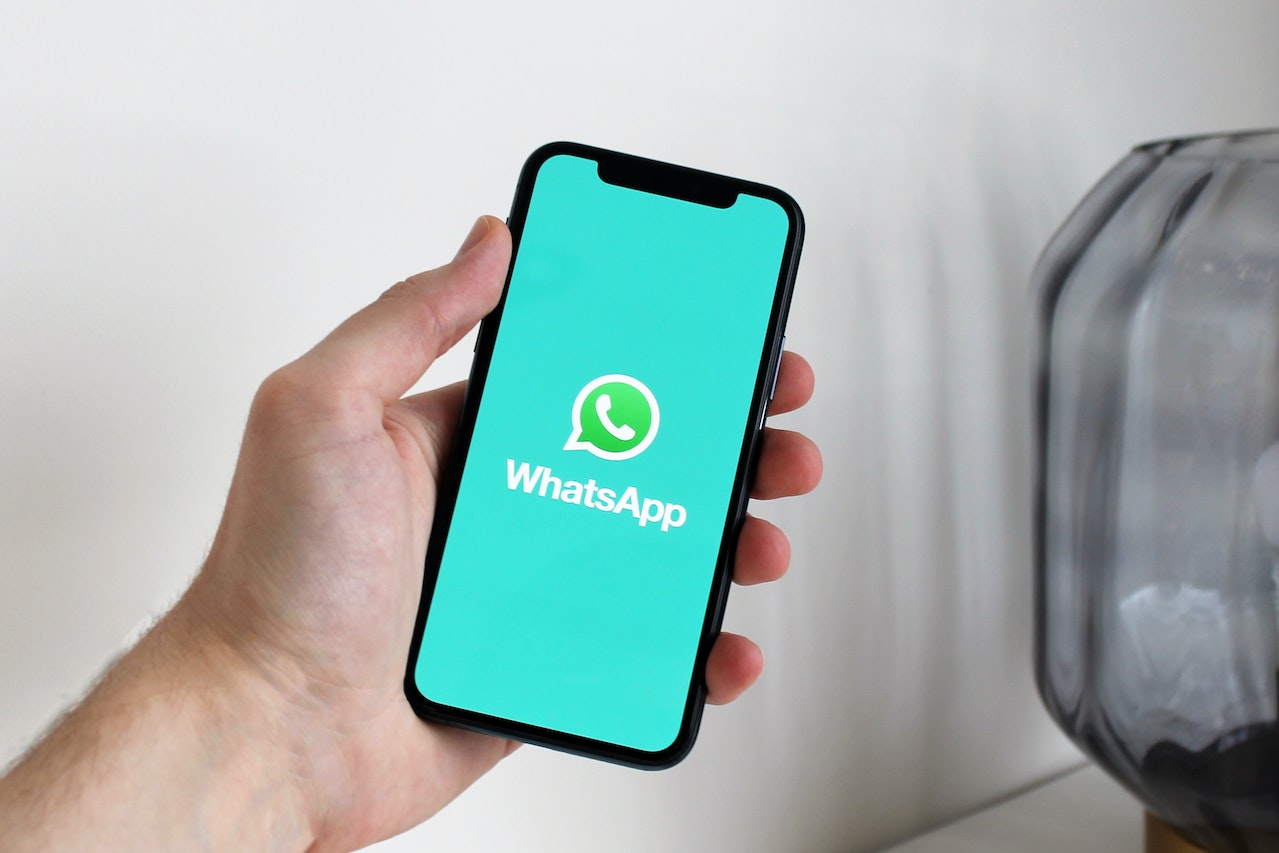 una mano sosteniando un teléfono movil, logo de whatsapp en la pantalla / Conoce las nuevas funciones de Whatsapp en 2023 / FOTO: Pexels