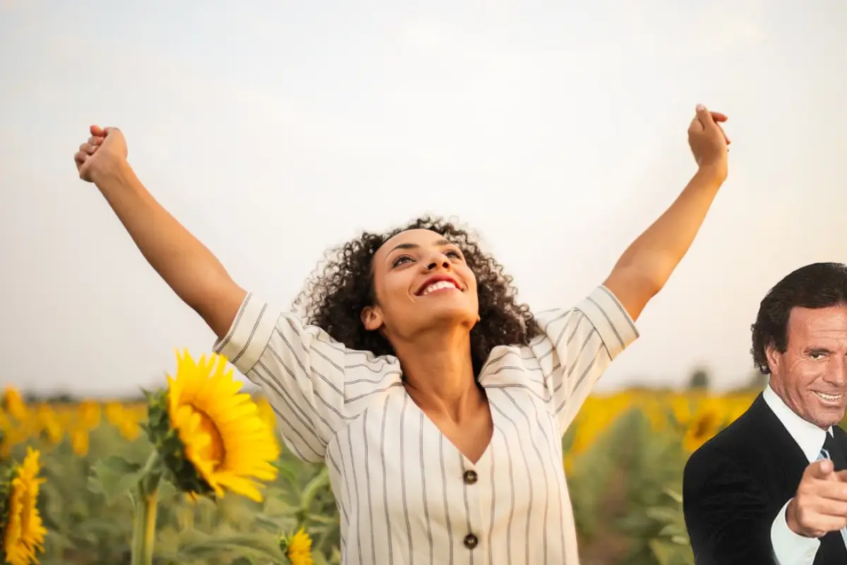 mujer con los brazos abiertos en posición de victoria, en un campo de girasoles, Julio