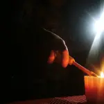 plano general de mano prendiendo una vela