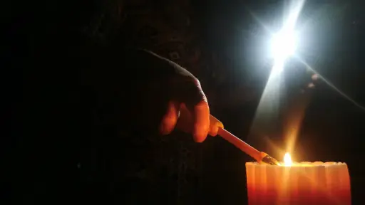 plano general de mano prendiendo una vela