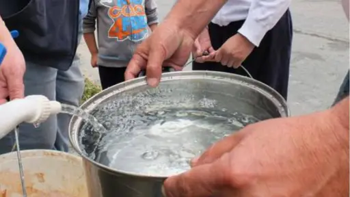 plano general de gente juntando agua