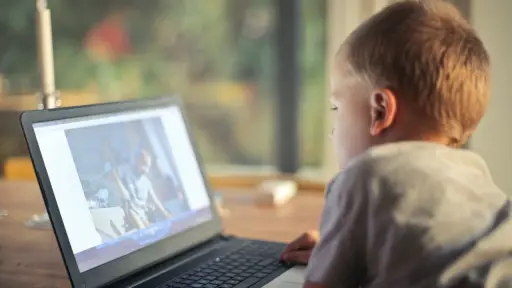 un niño mira una pantalla de computador durante sus vacaciones de invierno