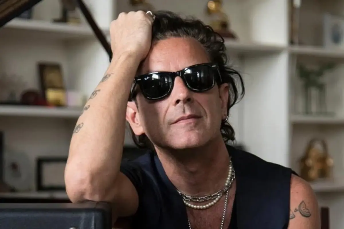 Cantante argentino coti con lentes oscuros y la mano sobre la cabeza