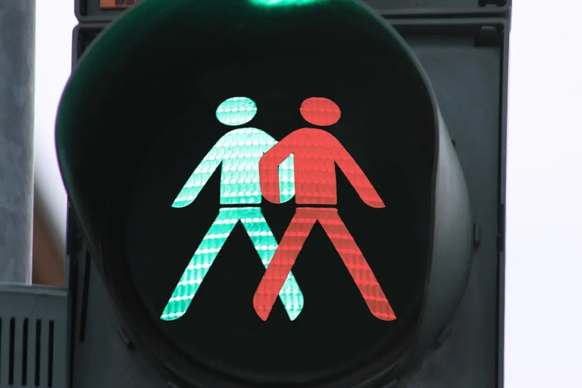 un semáforo muestra los símbolos de caminante en verde y rojo al mismo tiempo como señal de incompatibiidad, signos del zodiaco