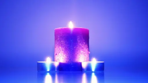 tres velas encendidas en un entorno azulado, para mostrar el hechizo de amor de las velas