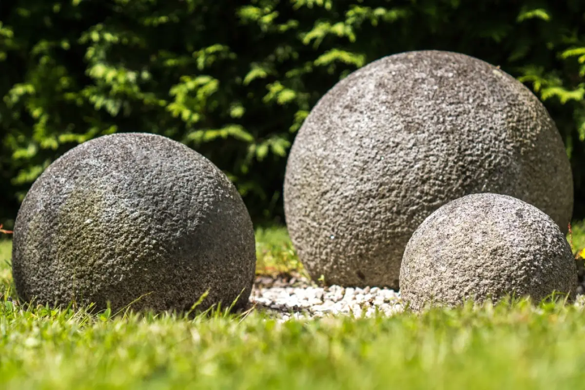tres enormes rocas con forma redonda sobre el pasto