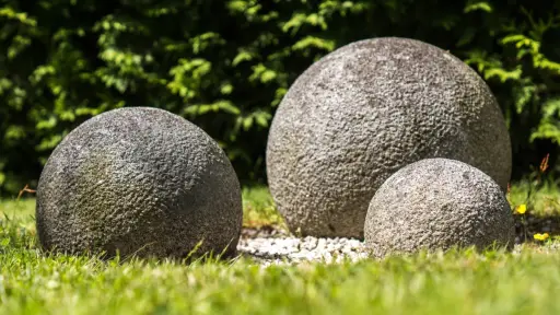 tres enormes rocas con forma redonda sobre el pasto