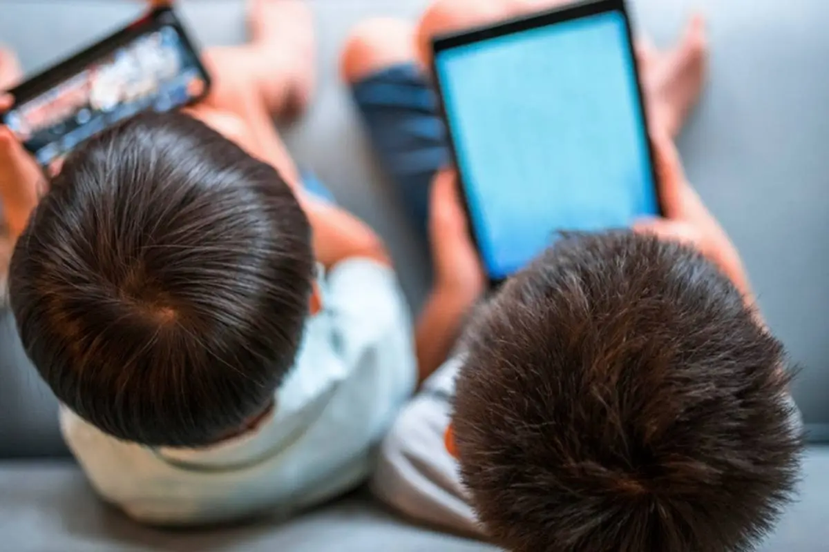 plano general de niños usando pantallas