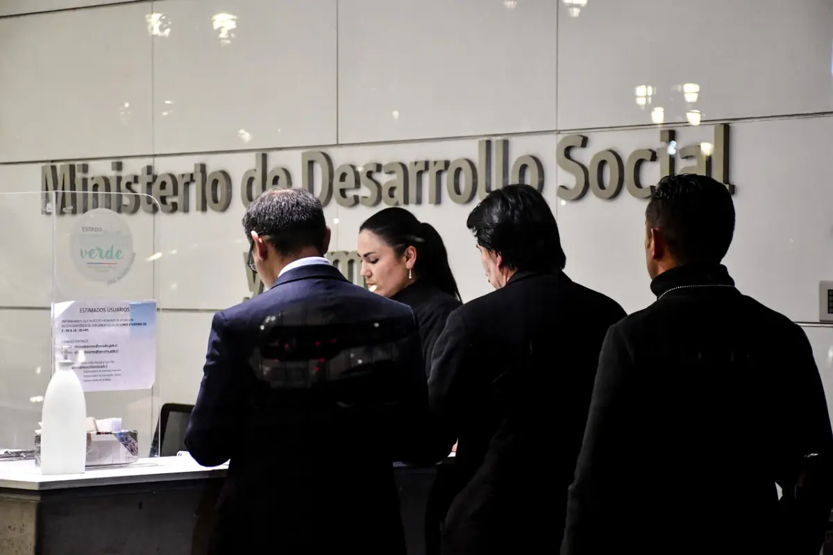 Cuatro personas de espaldas en el frontis del Ministerio de Desarrollo Social