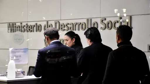 Cuatro personas de espaldas en el frontis del Ministerio de Desarrollo Social