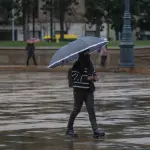 una mujer con un paraguas bajo la lluvia