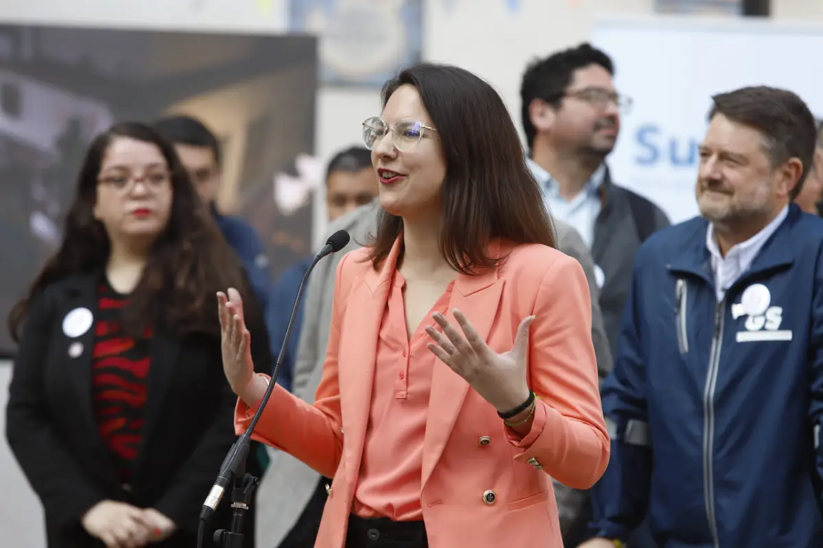 Irací Hassler frente a un micrófono vestida con un conjunto color naranjo