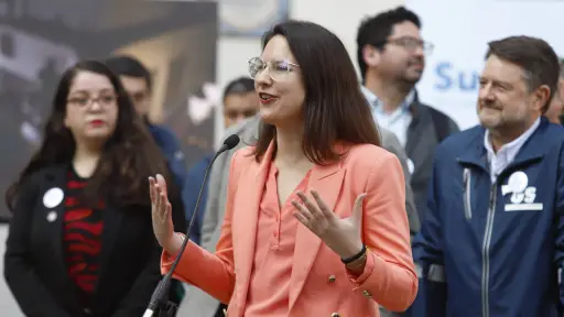 Irací Hassler frente a un micrófono vestida con un conjunto color naranjo