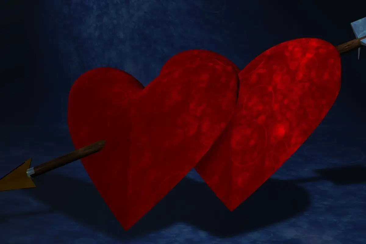 dos corazones de tela atravezados por una flecha
