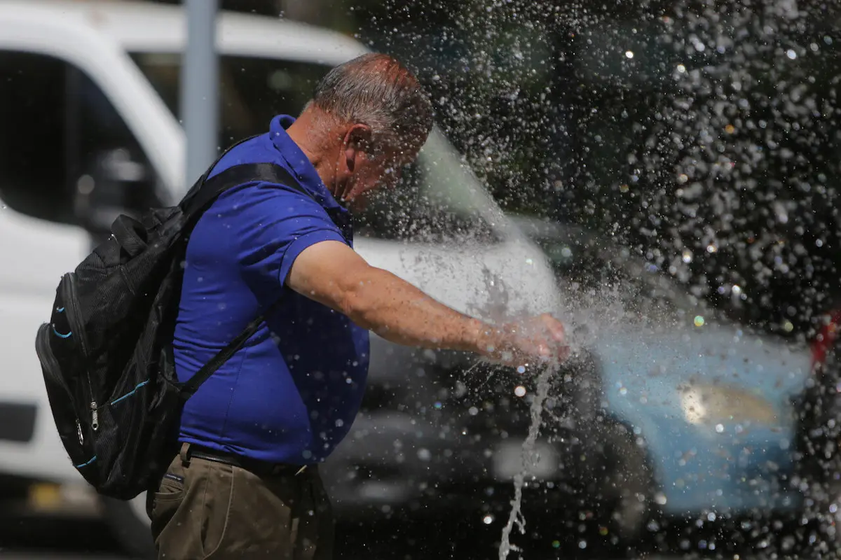 plano general de persona mojándose por ola de calor