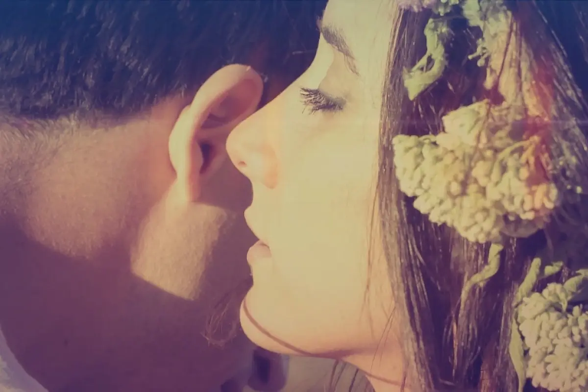 una mujer susrurrando al oído de su pareja