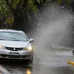 plano general de auto mojando a peatones