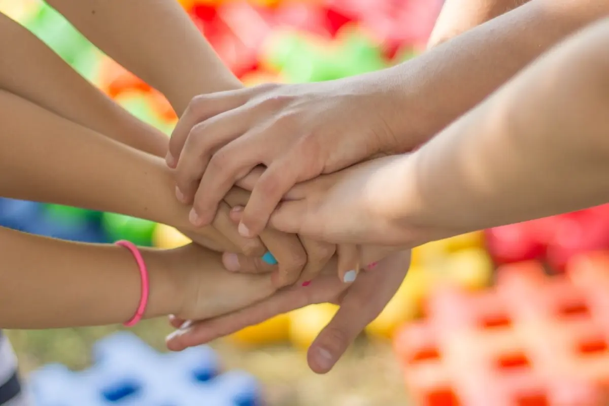 un grupo amigos y de manos reunidas en el centro en señal de amistad