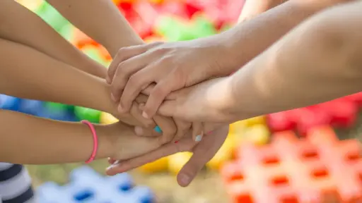 un grupo amigos y de manos reunidas en el centro en señal de amistad