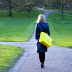 una mujer vestida de negro caminando, llega a una bifurcación de caminos