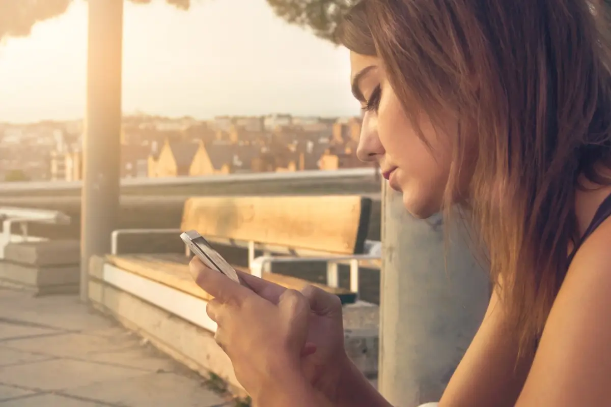 una mujer escribe en su telefono para mejorar la comunicacion familiar con los suyos
