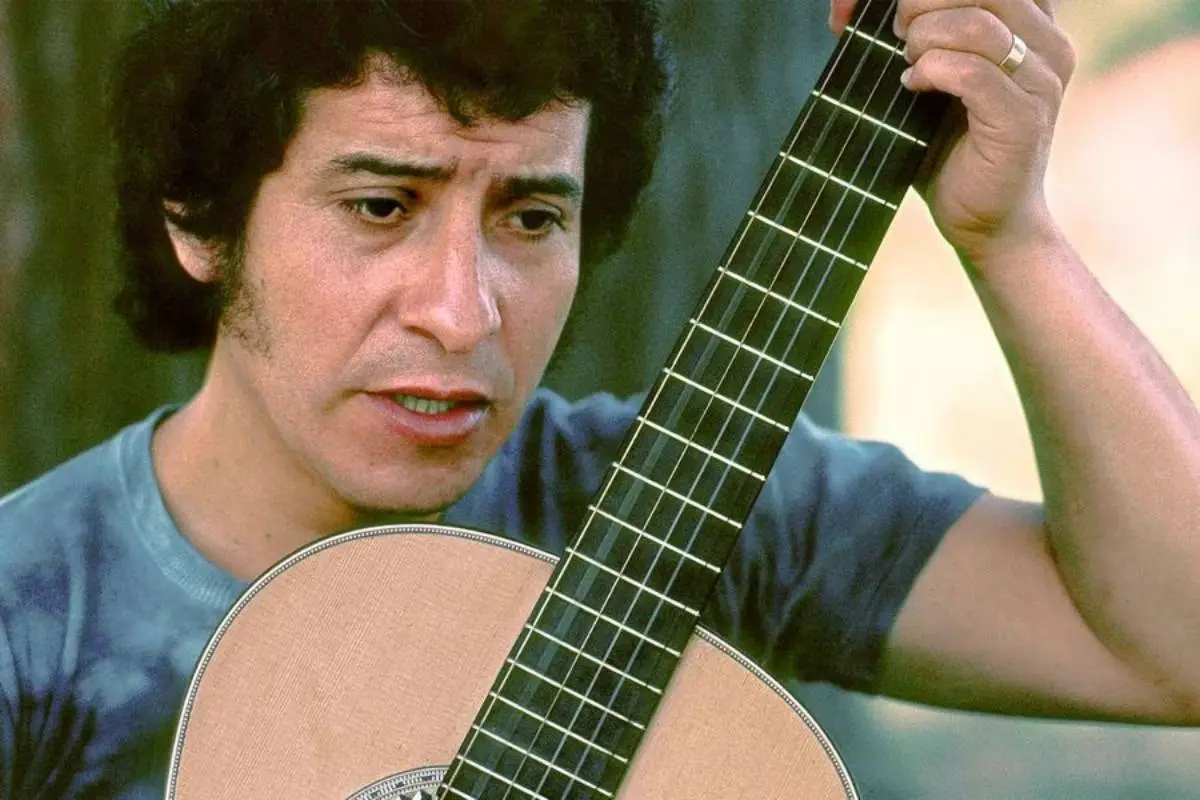Víctor Jara sosteniendo una guitarra