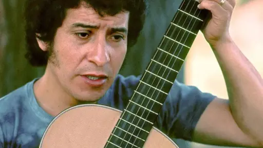 Víctor Jara sosteniendo una guitarra
