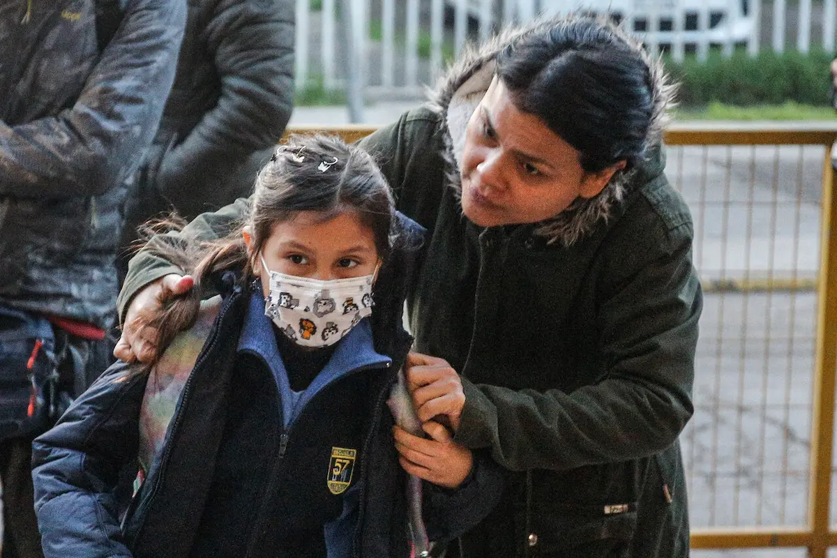 mamá llevando a su hijo al colegio por bono escolar