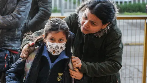 mamá llevando a su hijo al colegio por bono escolar