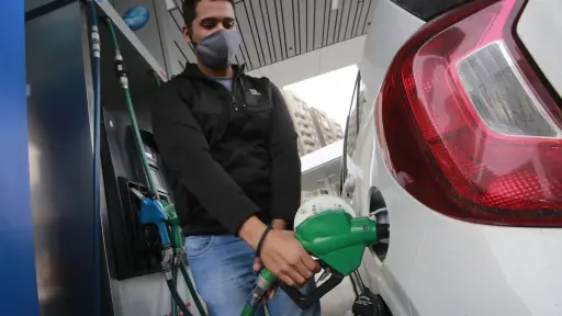 persona echando bencina a automóvil en una gasolinera