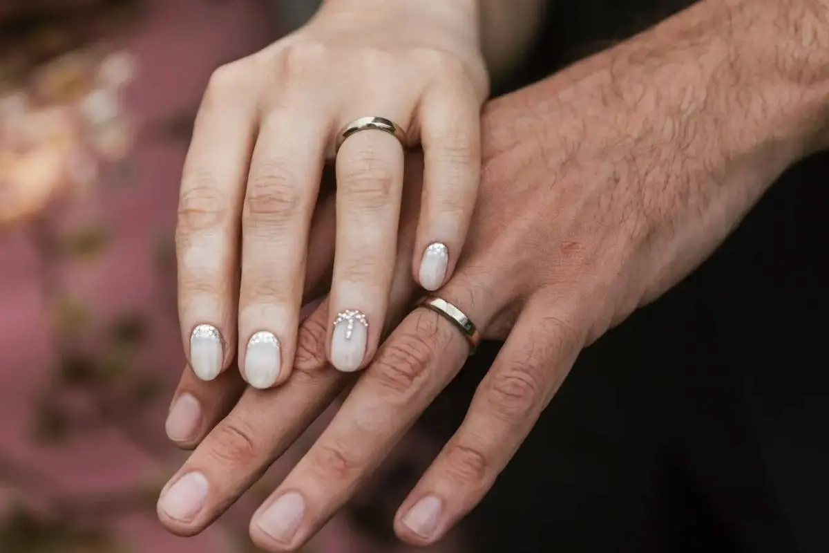 Pareja de recién casados mostrando sus anillos de matrimonio
