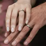 Pareja de recién casados mostrando sus anillos de matrimonio