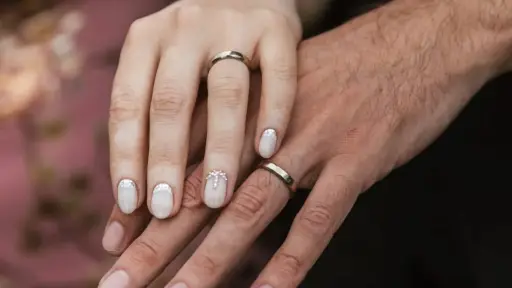 Pareja de recién casados mostrando sus anillos de matrimonio