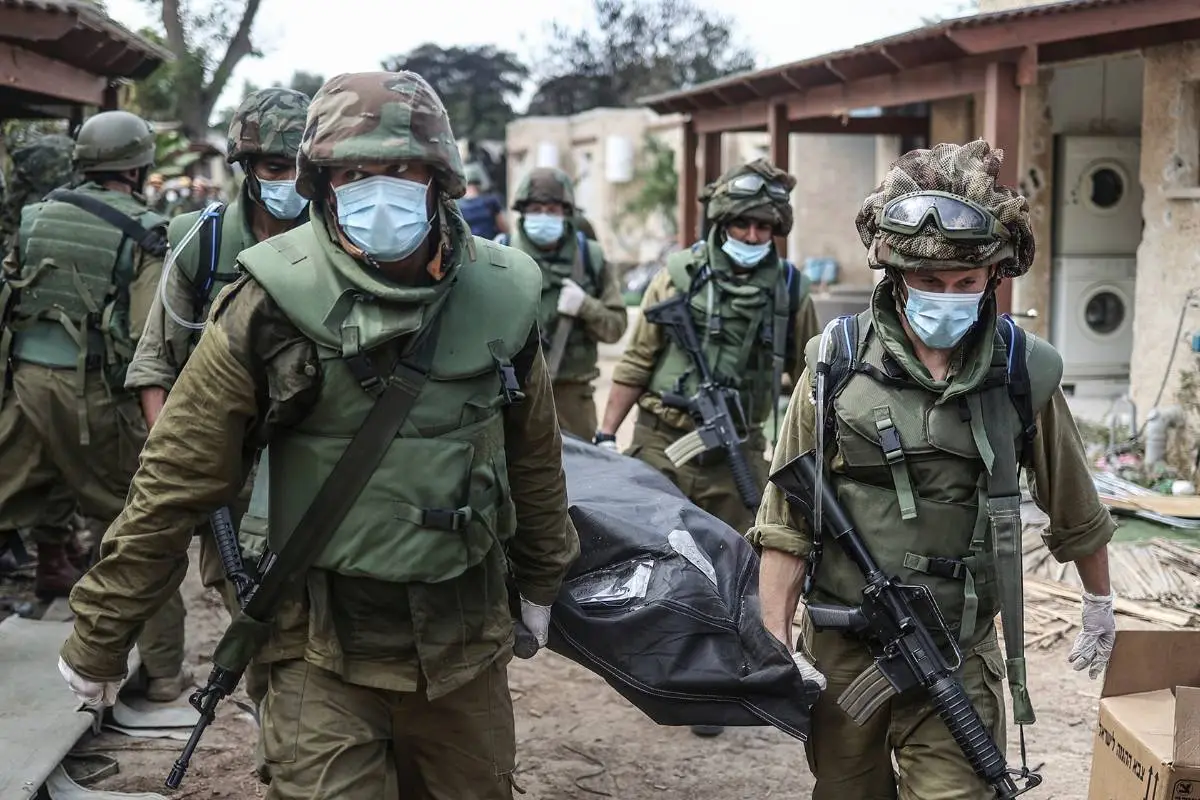 soldados de Israel transportan un cadáver tras el atentado de Hamás