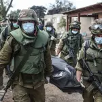 soldados de Israel transportan un cadáver tras el atentado de Hamás