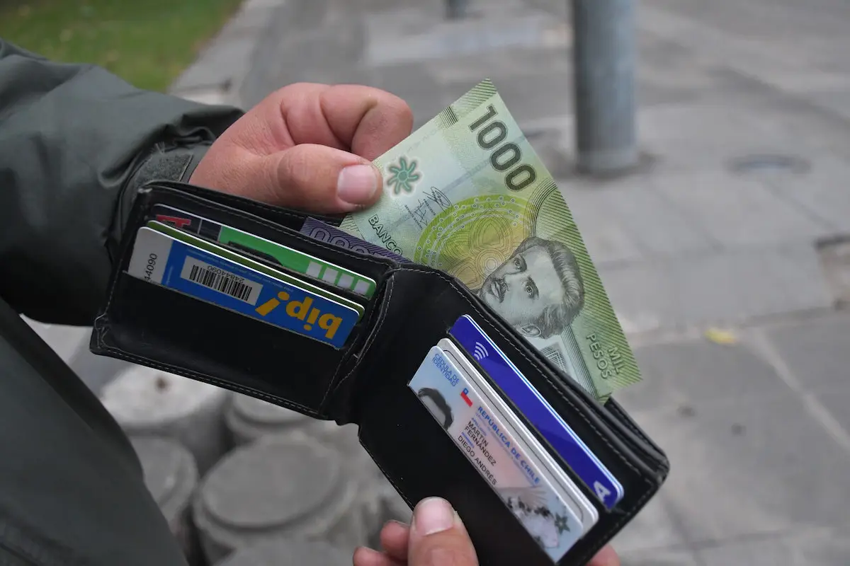 biletera abierta con tarjetas y un billete de mil pesos